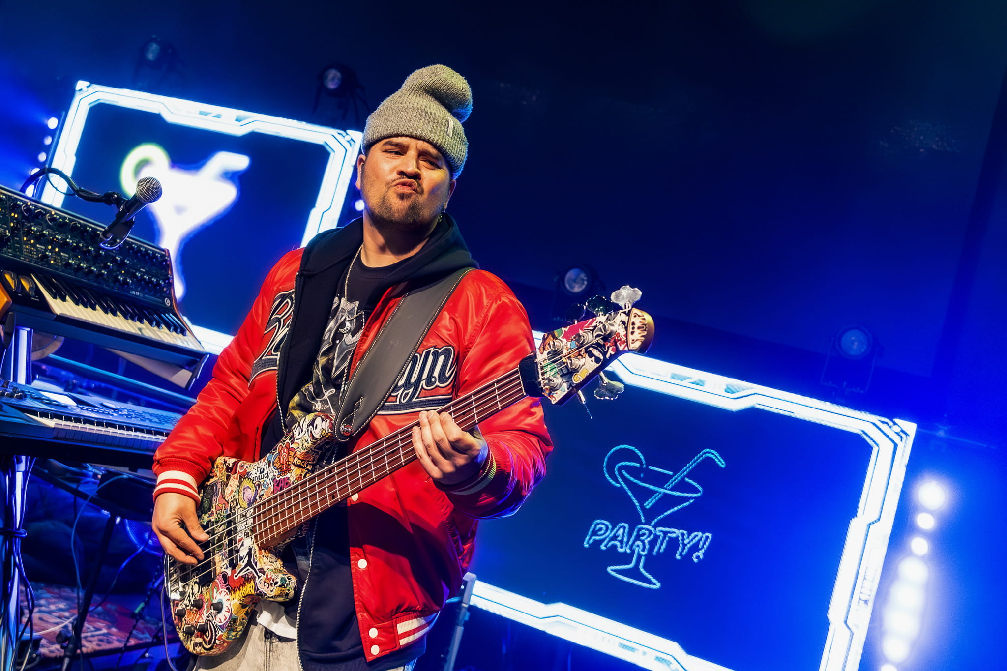 Bassist van Monkey Squad in een rode jas tijdens het optreden