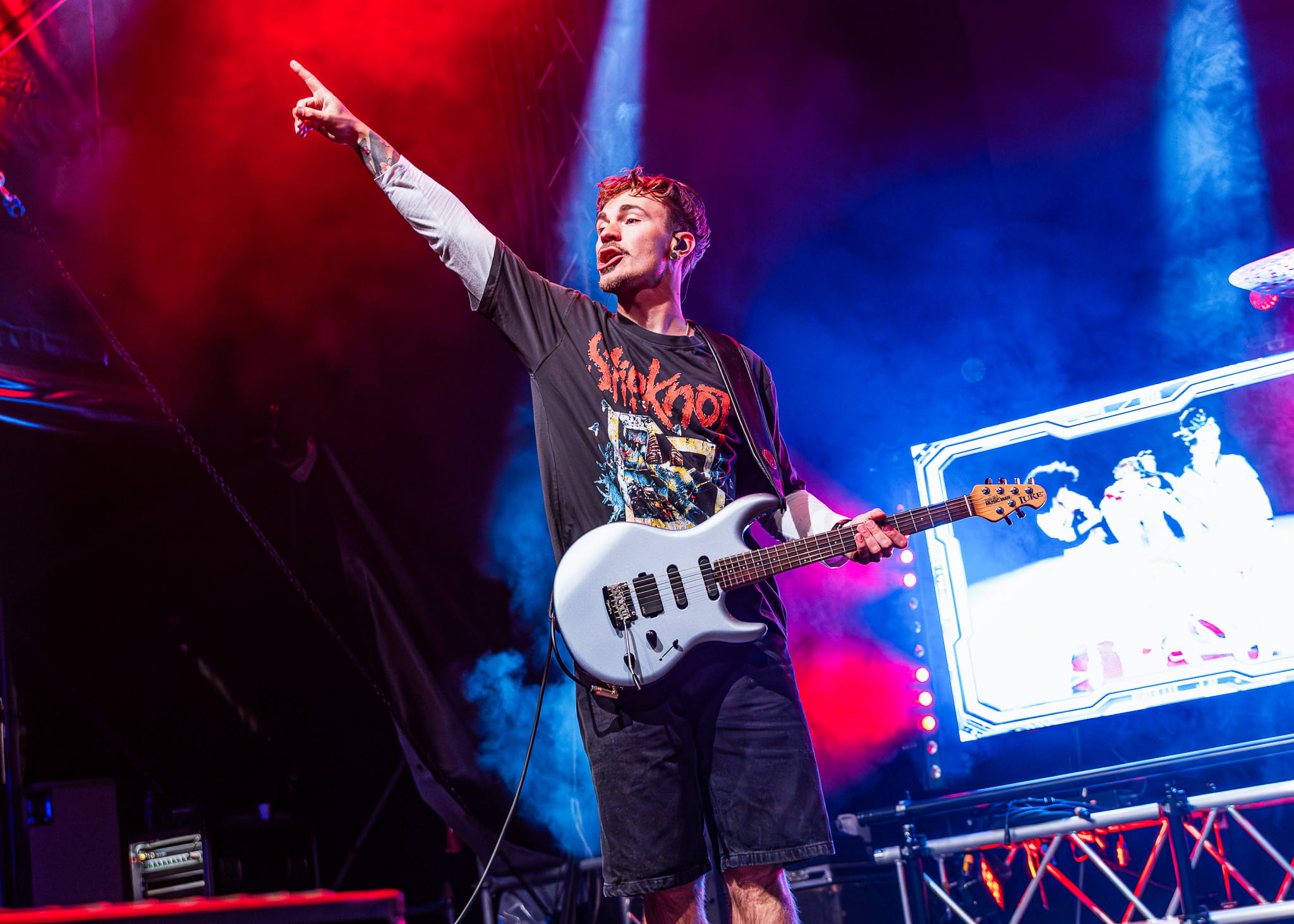 Gitarist van Monkey Squad wijst het publiek in met zijn witte gitaar